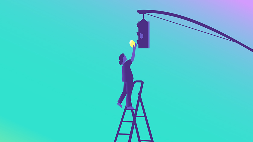 A person on a stepladder replacing the yellow light on a stoplight.