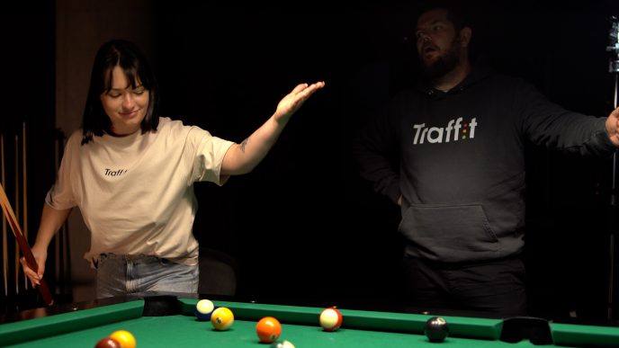 Two people around a pool table wearing Traffit apparel