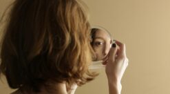 Tvang. Bildet viser en kvinne som ser seg i speilet.