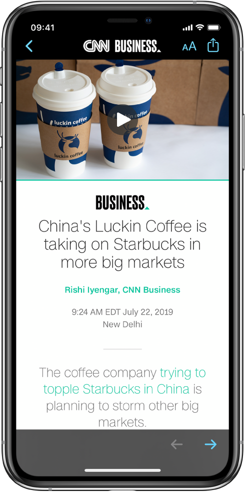 En artikkel fra Apple News. Øverst til venstre på skjermen er Tilbake-knappen for å gå tilbake til Aksjer-appen. Øverst til høyre på skjermen er Tekstformat- og Del-knappen. Nede til høyre er Neste side-knappen.