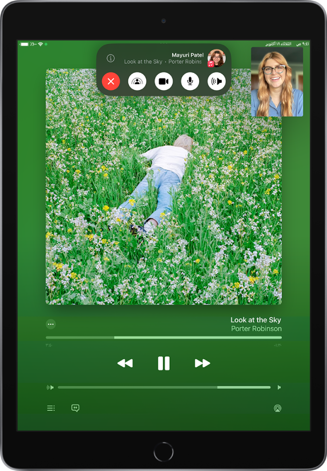 مكالمة فيس تايم، تعرض محتوى صوتي من Apple Music تتم مشاركته في المكالمة. يظهر غلاف الألبوم بالقرب النصف العلوي من الشاشة، ويظهر أسفله مباشرةً العنوان وعناصر التحكم في الصوت. في الجزء العلوي توجد عناصر التحكم في فيس تايم، بما في ذلك أزرار الصوت والميكروفون والكاميرا و SharePlay وإنهاء. فوق عناصر التحكم يظهر Apple ID الخاص بالمجموعة أو الشخص الذي تتحدث إليه بجانب زر المعلومات.