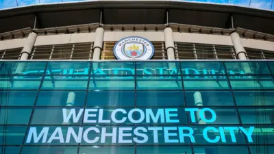 スタジアム正面のアップの写真。前面にWELCOME TO MANCHESTER CITYの文字が見える