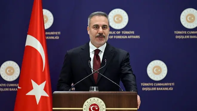 Dışişleri Bakanı Hakan Fidan, Dışişleri Bakanlığı logolu podyumda açıklama yaparken.