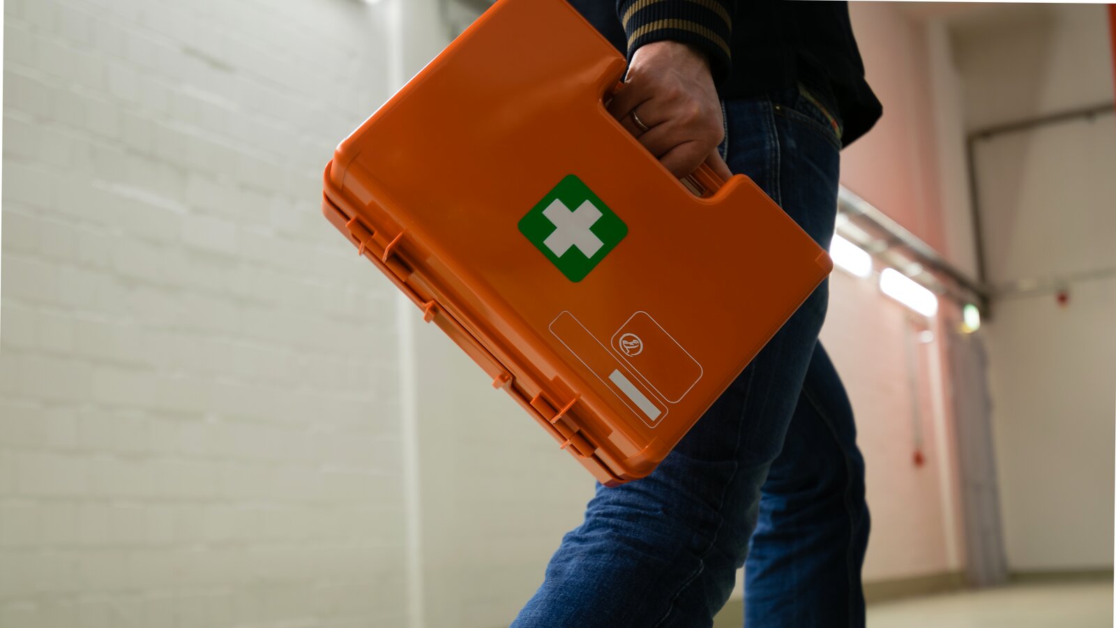 Mann går med førstehjelpskoffert i hånden