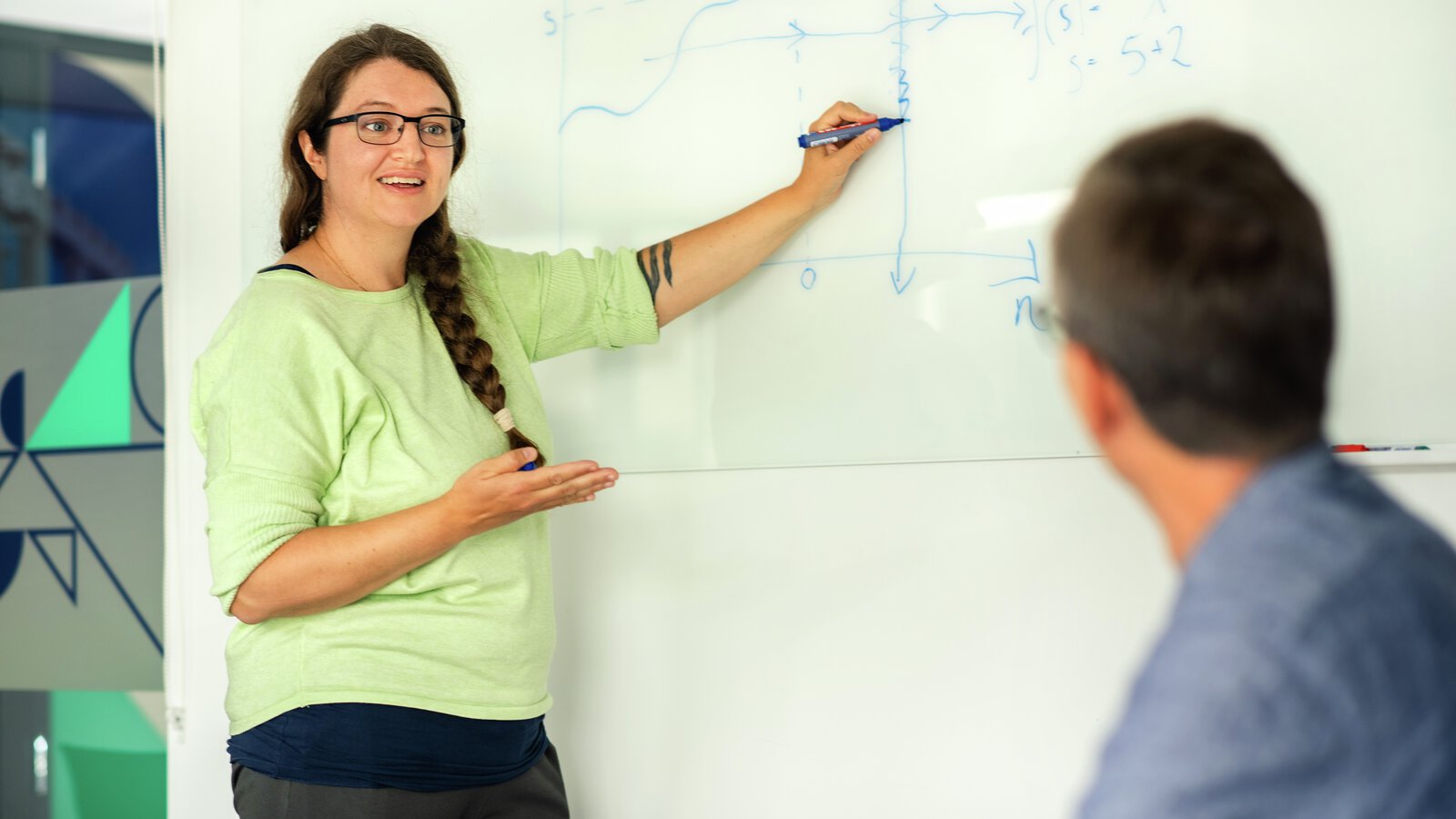 En person  forklarer ved et whiteboard
