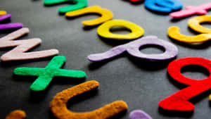Lettere e numeri di feltro colorati su sfondo grigio scuro per apprendimento o gioco. — Font Sfondi