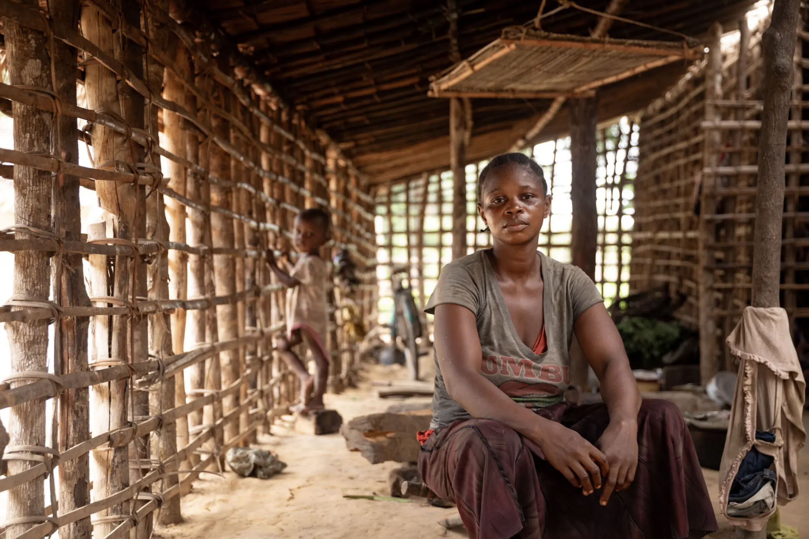 A photograph showing two figures indoors, with the figure on the foreground looking at the camera