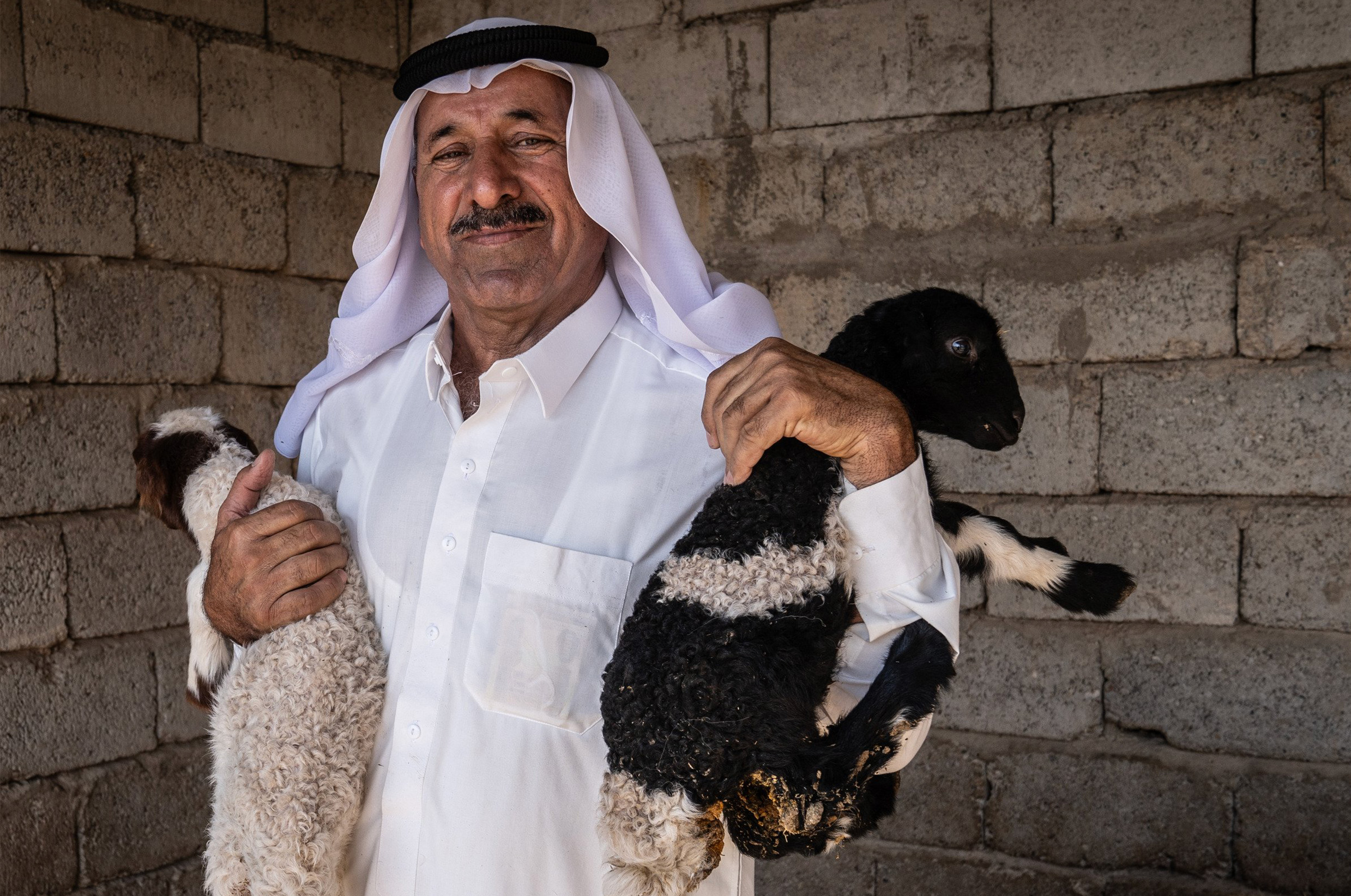 A photograph of a group of women, with the central figure draped in a colourful flag